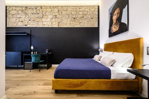 a bedroom with a king sized bed and a brick wall at Interno Barocco in Naples