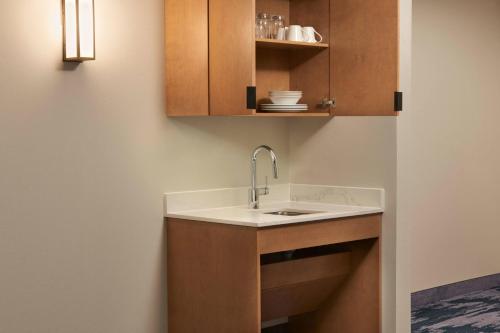 uma cozinha com um lavatório e armários de madeira em Fairfield by Marriott Inn & Suites Orillia em Orillia