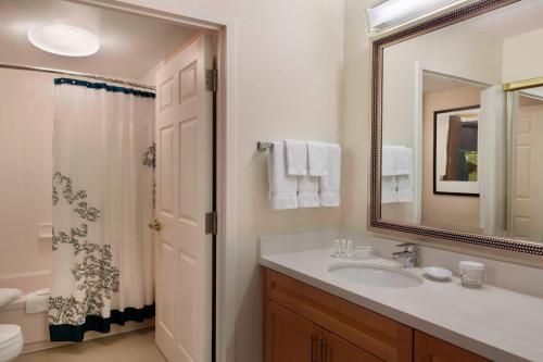 a bathroom with a sink and a mirror and a shower at Residence Inn by Marriott Toronto Markham in Markham