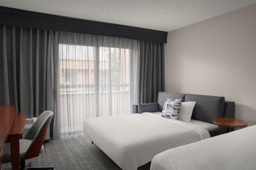 ein Hotelzimmer mit einem Bett und einem Fenster in der Unterkunft Courtyard by Marriott Portland Beaverton in Beaverton
