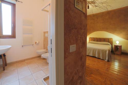 a bathroom with a bedroom with a bed and a sink at Art Rooms Joyful People in Alberobello
