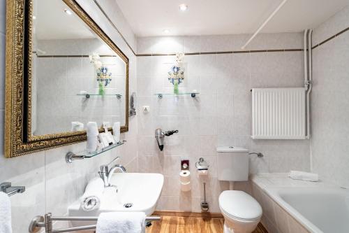 a bathroom with a sink and a toilet and a mirror at Hotel Burg Trendelburg in Trendelburg