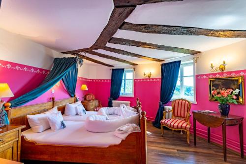 2 Betten in einem Zimmer mit rosa Wänden in der Unterkunft Hotel Burg Trendelburg in Trendelburg