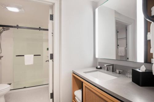 a bathroom with a sink and a toilet and a mirror at Residence Inn by Marriott Miami Aventura Mall in Aventura