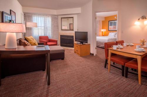 uma suite de hotel com uma sala de estar e um quarto em Residence Inn Frederick em Frederick