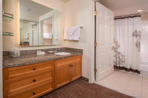 a bathroom with a sink and a mirror and a shower at Residence Inn Frederick in Frederick