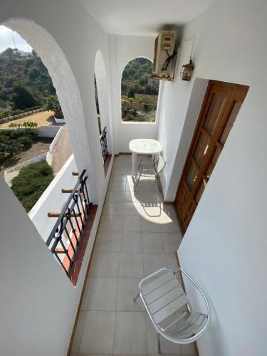 a room with a balcony with a table and chairs at Hotel Simón in Mojácar