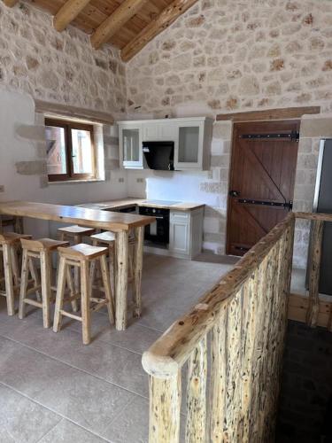 eine Küche mit einem Holztisch und Stühlen im Zimmer in der Unterkunft Villa Asteria in Melidhónion