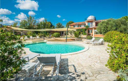 a swimming pool with chairs and a house at Beautiful Home In Valtura With House A Panoramic View in Valtura