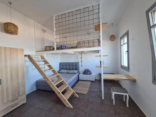 Habitación pequeña con litera y escalera en Κατοικία Uppolis με θέα τα νησιά, en Ano Syros