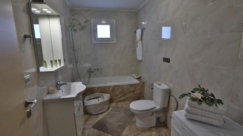 a bathroom with a toilet and a sink and a tub at Villa Meli in Rethymno Town