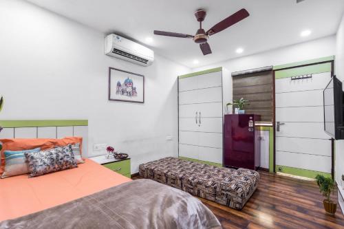 um quarto com uma cama e uma ventoinha de tecto em Homlee-Heritage 2-Bed Room Apt near Pragati Maidan em Nova Deli