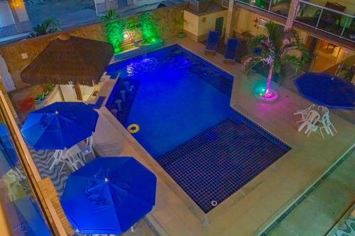 an overhead view of a swimming pool with umbrellas at Pousada Palmares in Cabo Frio