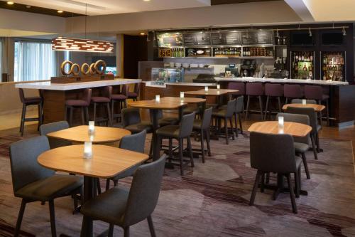 een restaurant met houten tafels en stoelen en een bar bij Courtyard by Marriott Memphis East/Park Avenue in Memphis