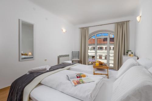 a bedroom with two white beds and a window at Main View Apartment in Rijeka