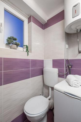 a bathroom with a toilet and a window at Main View Apartment in Rijeka