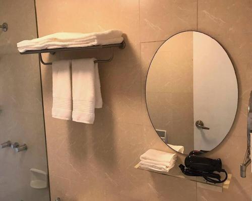 a bathroom with a mirror and towels on a shelf at Spacious BGC 2 BR with a view in Manila
