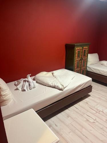 two beds in a room with a red wall at Hotel Vi Vintage S-Weilimdorf in Stuttgart-Weilimdorf