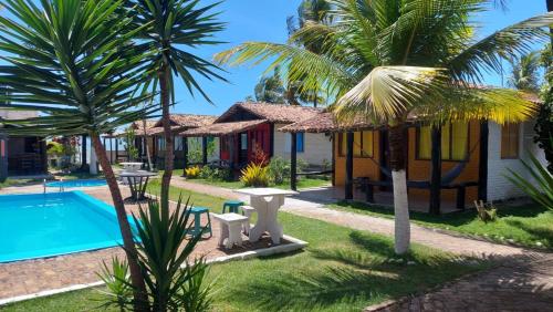 a villa with a pool and a resort at Pousada A Vila do Pirata in Prado
