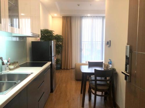 une cuisine avec une table et une cuisine avec une salle à manger dans l'établissement NK#Homestay#Greenbay#Studio#C2, à Hanoï