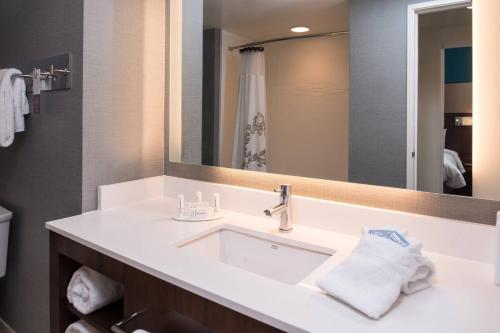 een badkamer met een witte wastafel en een spiegel bij Residence Inn by Marriott St. Louis Westport in Maryland Heights