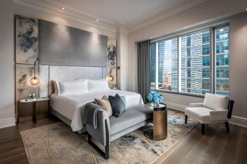 um quarto com uma cama, uma cadeira e uma janela em The St. Regis Toronto em Toronto