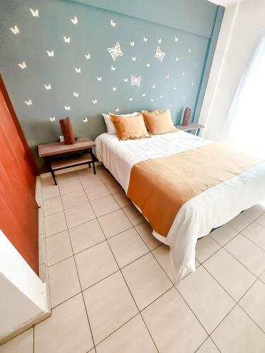 ein Schlafzimmer mit einem Bett und einer Wand mit Vögeln darauf in der Unterkunft Hermoso Departamento amplio con BALCÓN in Cordoba