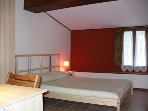 トッレ・デル・ラーゴ・プッチーニにあるLa casa dei coloriの赤い壁のベッドルーム1室(ベッド2台付)