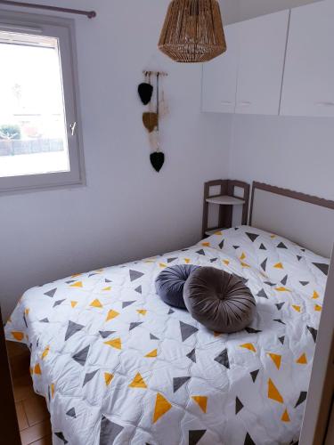un lit avec des oreillers dessus dans une chambre dans l'établissement JEAN BART I Joli T2 cabine proche plage Richelieu Cap d'Agde, au Cap d'Agde