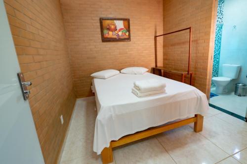 a bedroom with a bed with two towels on it at Flats Oliveira in Pirenópolis