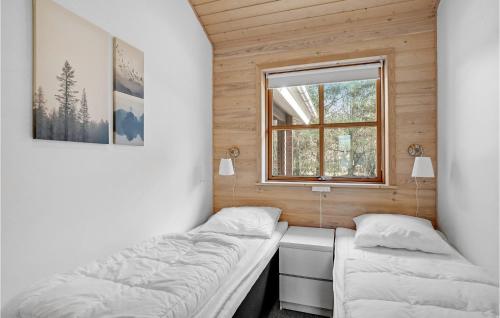 Stunning Home In Lgstr With Wifi في Trend: سريرين في غرفة صغيرة مع نافذة