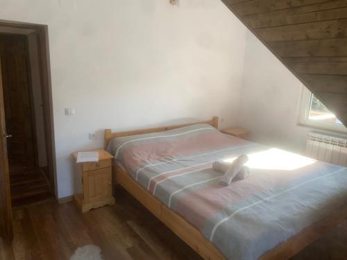 a white teddy bear sitting on a bed in a bedroom at Rustic House Busteni in Buşteni