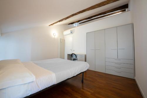een slaapkamer met een wit bed en een kast bij Apartment Sant'Alessandro 19 - Sostify in Bergamo