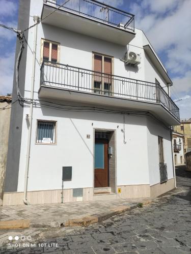 a white building with a balcony on top of it at La casetta di Anna in Palazzolo Acreide