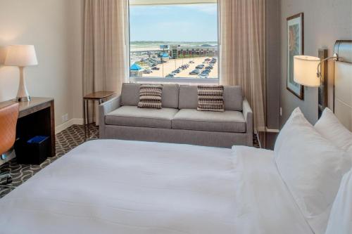 una camera d'albergo con letto e divano di Marriott St. Louis Airport a Edmundson