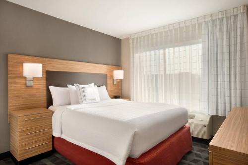 ein Schlafzimmer mit einem großen Bett und einem Fenster in der Unterkunft TownePlace Suites by Marriott Milwaukee Grafton in Grafton