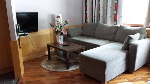 a living room with a couch and a table with flowers at Hotell Toppen in Storuman