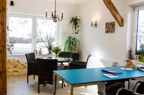 uma sala de jantar com uma mesa azul e cadeiras em Haidegger Appartements em Innsbruck