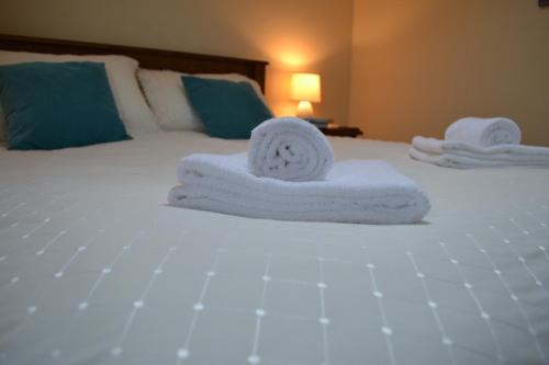 Una cama con toallas blancas encima. en Willow cottage, romantic retreat near Honiton Devon en Honiton