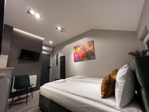 a bedroom with a bed and a painting on the wall at Comfort Hostel Klaipeda in Klaipėda