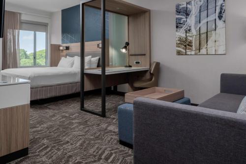 ハンターズビルにあるSpringHill Suites by Marriott Charlotte Huntersvilleのベッドとソファ付きのホテルルーム