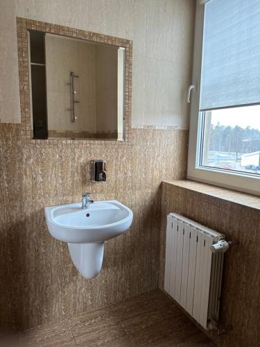 baño con lavabo, espejo y radiador en Zajazd Irina, en Białystok