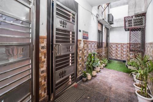 a hallway with plants in pots in a building at Homlee-Villa Luxury-2BHK-Anand Vihar-Ramprastha in Ghaziabad