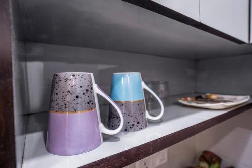 two coffee mugs sitting on a shelf in a kitchen at Homlee-Villa Luxury-2BHK-Anand Vihar-Ramprastha in Ghaziabad