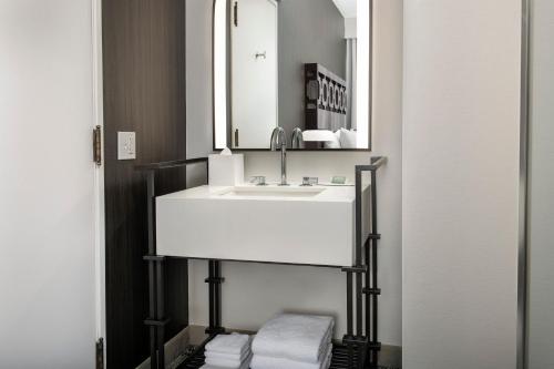 a bathroom with a sink and a mirror and towels at Courtyard by Marriott San Diego Downtown in San Diego