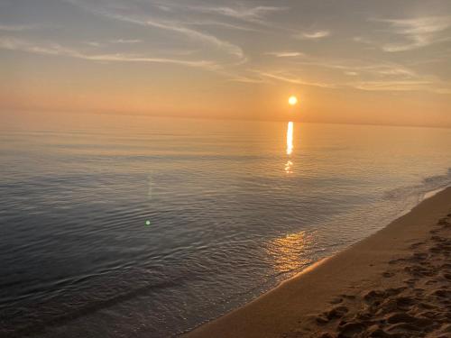 un tramonto sull'oceano con una spiaggia di CasaME’ a San Pietro in Bevagna