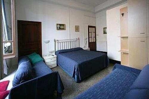 a bedroom with two beds and a couch at Hotel Fernanda in Rapallo