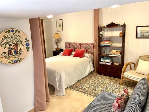 Un dormitorio con una cama con almohadas rojas y una silla en Apartamento en Casa Patio "Pan y Conejo", en Córdoba