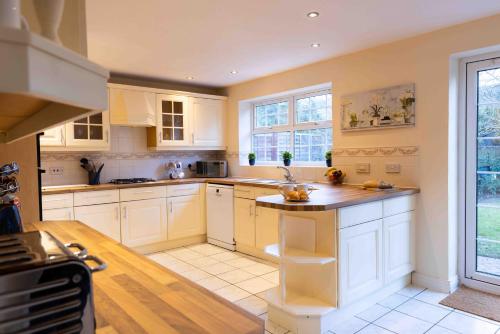 a large kitchen with white cabinets and a counter at Spacious 5 bedroom house in quiet cul-de-sac in Shrewsbury