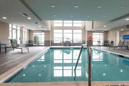 una piscina con sedie e tavoli in un edificio di Residence Inn by Marriott Toledo West a Toledo
